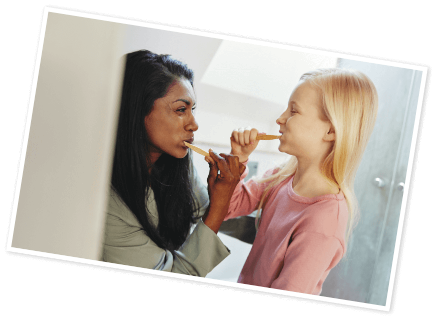 Photo of woman and a child brushing their teeth