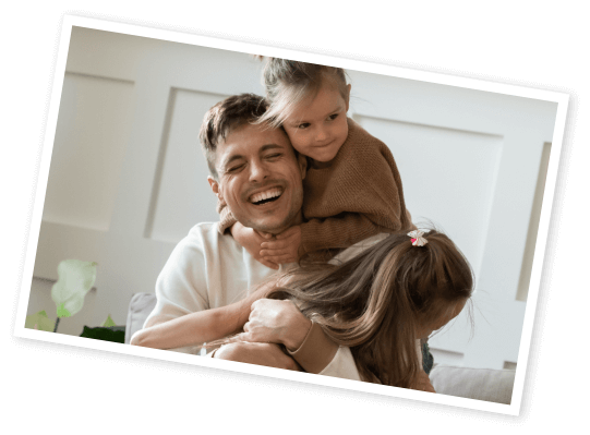 Photo of man holding hugging 2 children